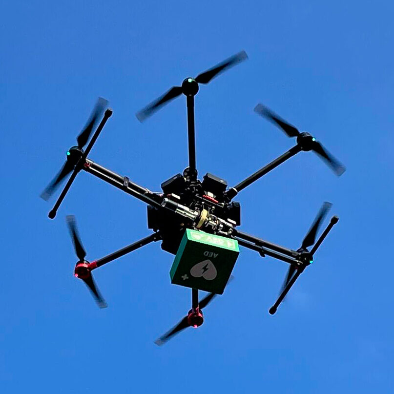 Photo montrant le drone spécialisé de Delivrone en plein vol, en train de livrer un défibrillateur.