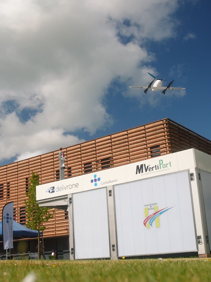 Photographie montrant le vertiport de Delivrone et son drone de transport médical s'envoler à côté d'un hôpital